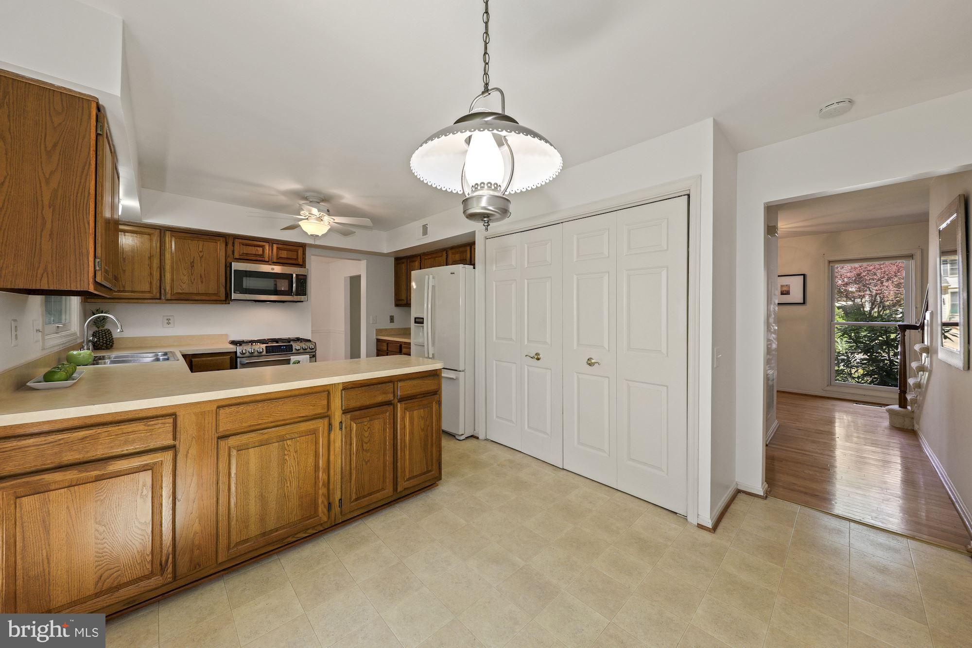 11321 Classical Lane Silver Spring, MD 20901 - Photo 13 of 35 a large kitchen with cabinets and a chandelier