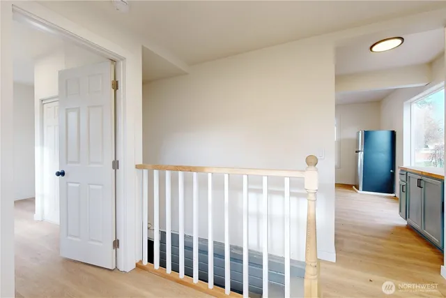 a view of a hallway with wooden floor and staircase