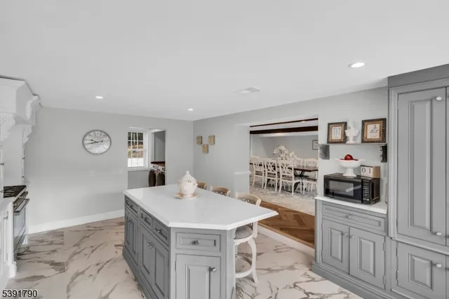 a view of kitchen with stainless steel appliances kitchen island granite countertop a refrigerator a sink a stove and white cabinets