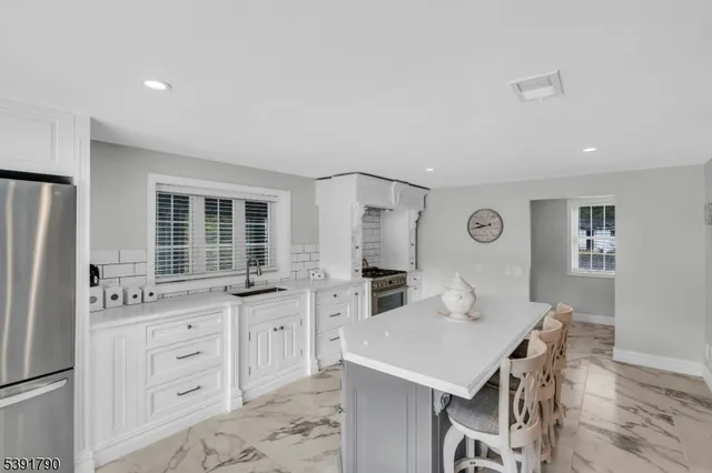 a kitchen with a table chairs refrigerator and cabinets