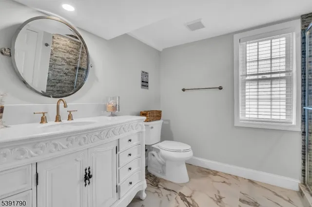 a bathroom with a toilet a sink and a mirror