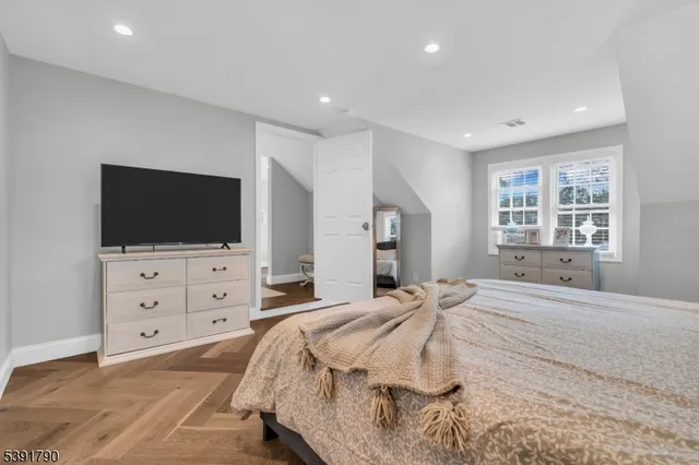 a bedroom with a bed and a flat screen tv in white dresser