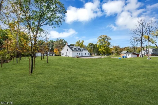 a view of a white house with a yard