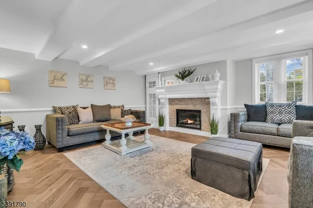 a living room with furniture a fireplace and a large window