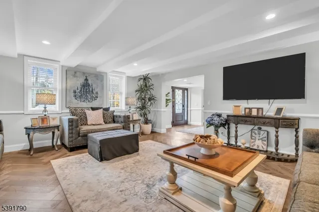 a living room with furniture a flat screen tv and a window