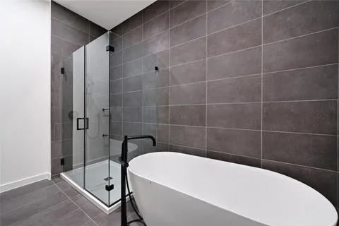 a white bath tub sitting next to a white wall