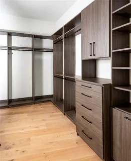 a view of a refrigerator in kitchen and white cabinets