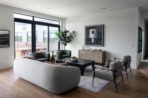 a living room with furniture potted plant and a large window