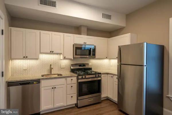 a kitchen with refrigerator a microwave and cabinets