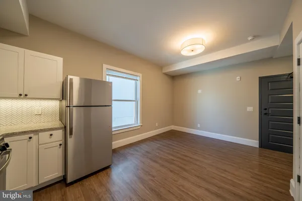 a kitchen with a refrigerator and a stove top oven