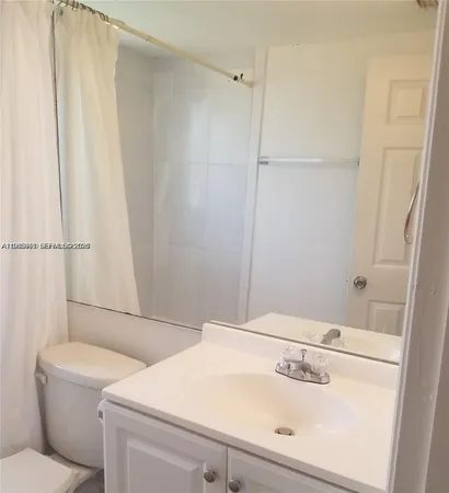 a bathroom with a sink a toilet and a shower