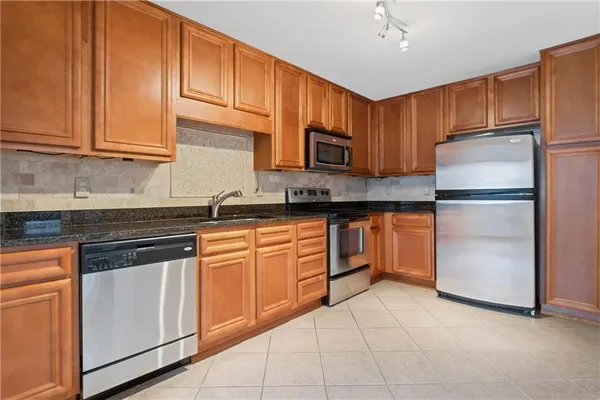 a kitchen with cabinets stainless steel appliances and a sink
