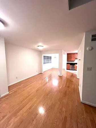 a view of empty room with wooden floor