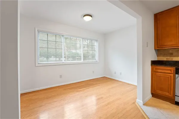 an empty room with windows and cabinet