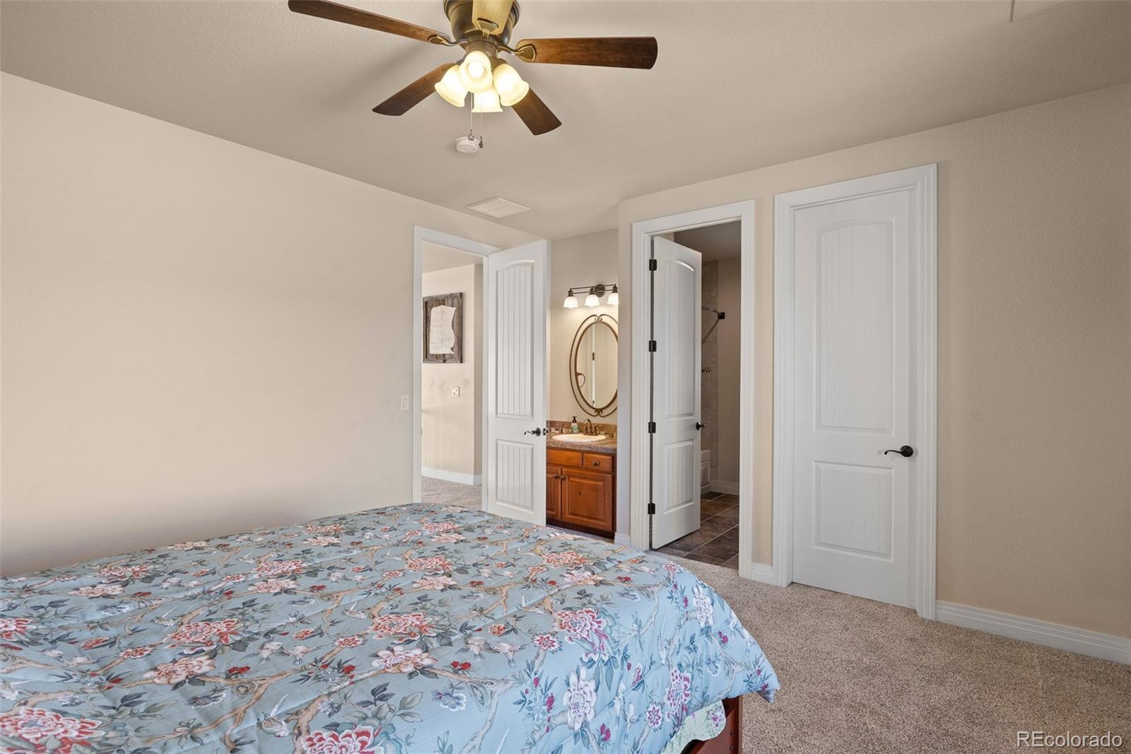 41865 East Muirfield Loop Elizabeth, CO 80107 - Photo 26 of 50 a bedroom with a bed and a chandelier