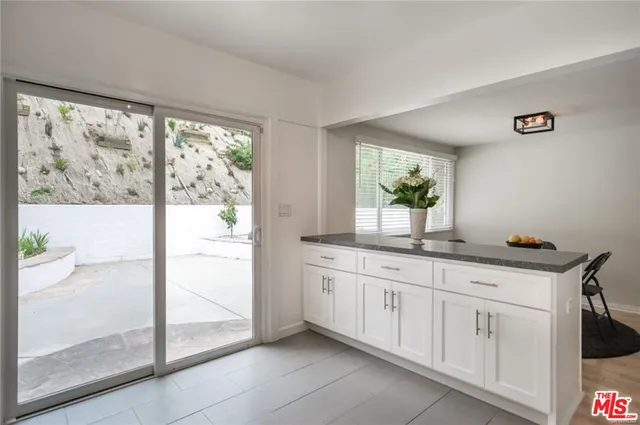 a bathroom with a granite countertop sink and a window