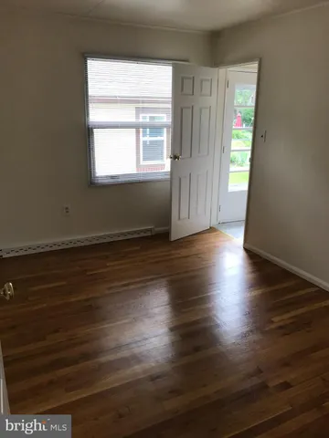 a view of a room with wooden floor and a window