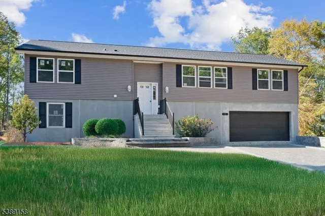 a front view of a house with a garden and yard