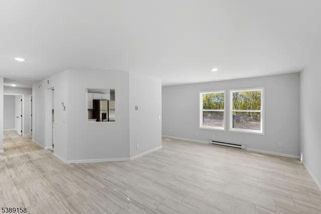 a view of a big room with wooden floor and windows