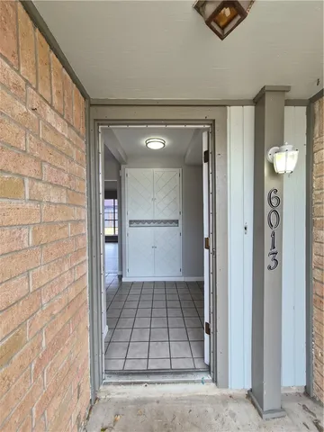 a view of a hallway with wooden floor and a bathroom