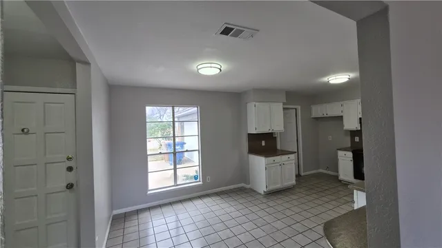 a view of a kitchen with refrigerator and more cabinets
