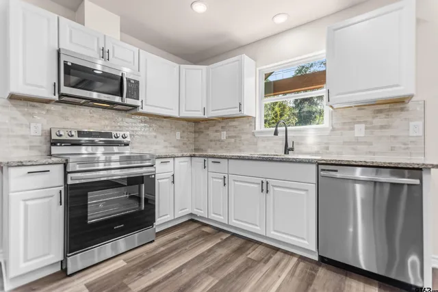 a kitchen with stainless steel appliances granite countertop a stove and a microwave