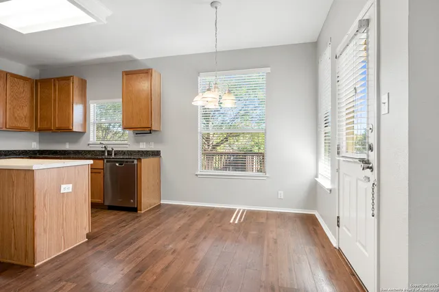 a kitchen with granite countertop wooden floors and wide window