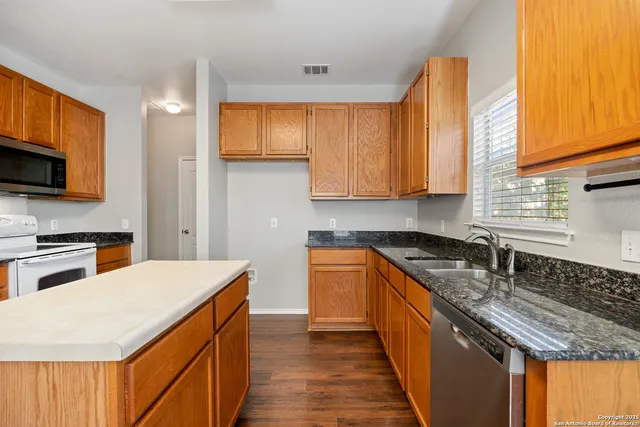 a kitchen with stainless steel appliances granite countertop a sink stove and refrigerator