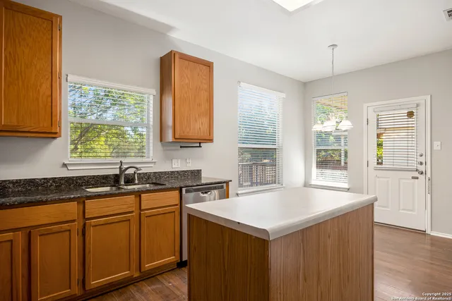 a kitchen with stainless steel appliances granite countertop a sink a stove and cabinets