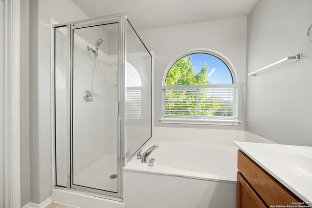 a bathroom with a window a sink and a shower