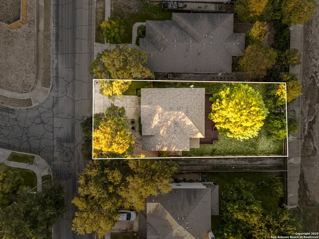 an aerial view of a residential houses with yard