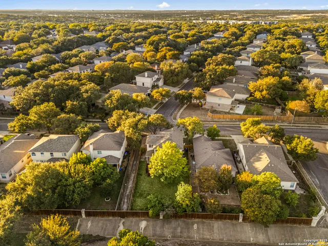 an aerial view of residential houses with outdoor space and swimming pool