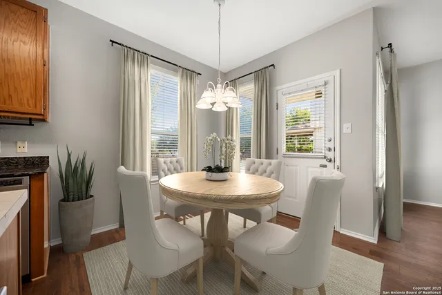 a dining room with furniture a chandelier and wooden floor