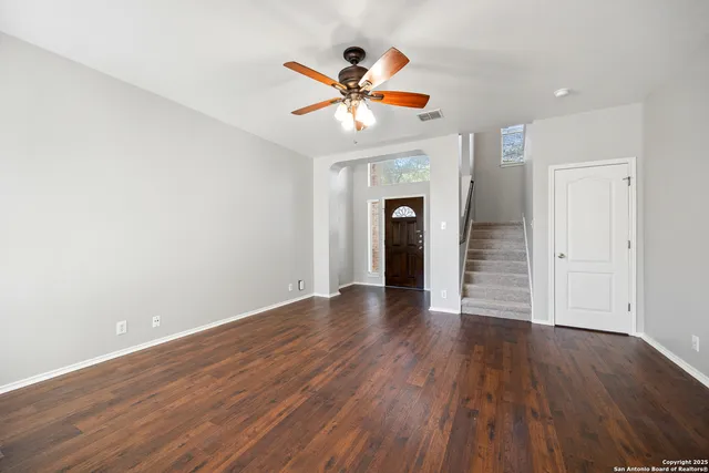 wooden floor in an empty room with a fan