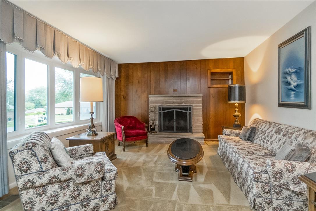 1328 Russett Road Allentown, PA 18104 - Photo 7 of 46 A comforting living space features a stone fireplace as its focal point, complemented by warm wood paneling.