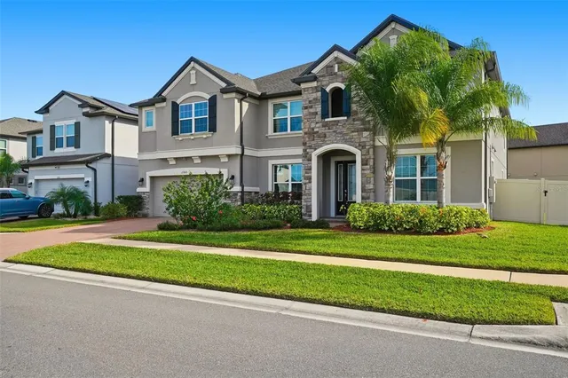 a front view of a house with a yard and potted plants