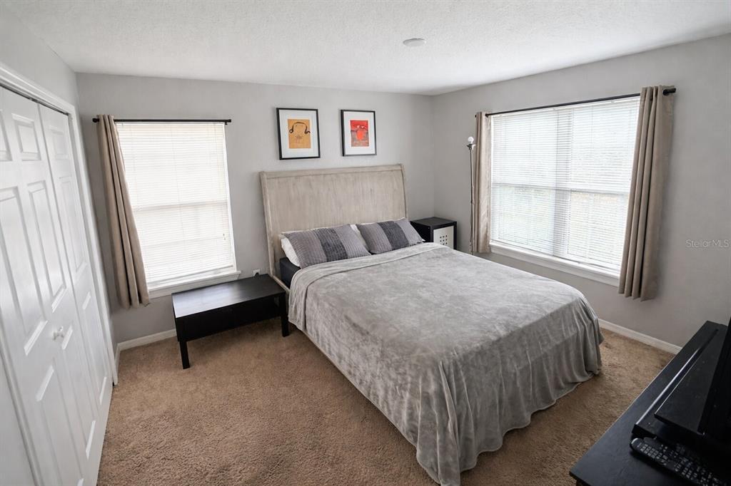 5483 Vineland Road, Unit 10301 Orlando, FL 32811 - Photo 11 of 13 a bed sitting in a bedroom next to a window