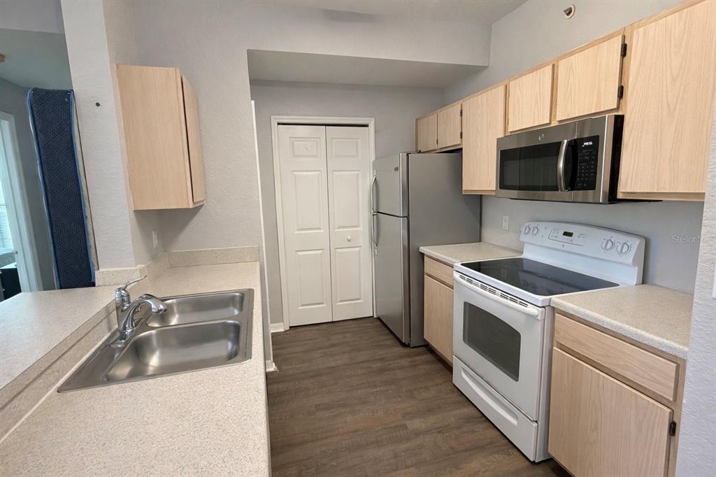 5483 Vineland Road, Unit 10301 Orlando, FL 32811 - Photo 6 of 13 a kitchen with stainless steel appliances granite countertop a sink and a refrigerator