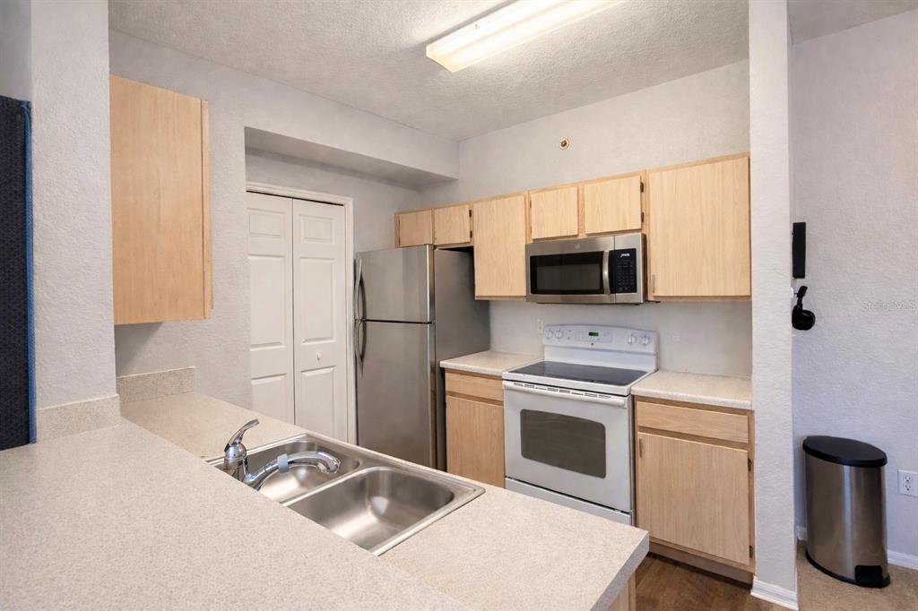 5483 Vineland Road, Unit 10301 Orlando, FL 32811 - Photo 7 of 13 a kitchen with a refrigerator stove and microwave