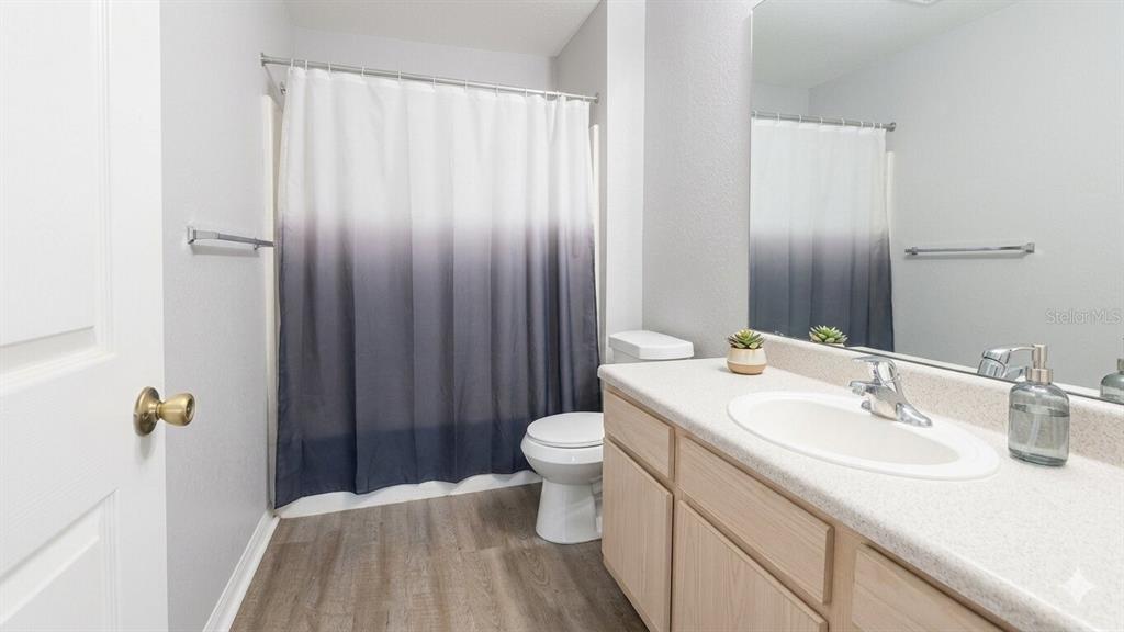 5483 Vineland Road, Unit 10301 Orlando, FL 32811 - Photo 10 of 13 a bathroom with a sink a toilet and shower curtain