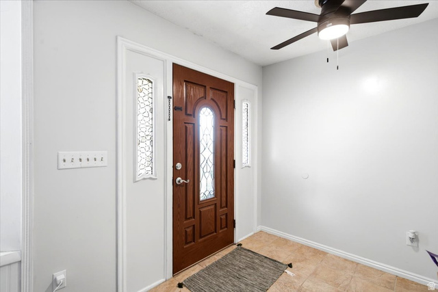 2455 South Bluff Road Syracuse, UT 84075 - Photo 8 of 32 Welcoming foyer featuring a solid wood entry door with decorative glass panels, sidelights, and transom window detail