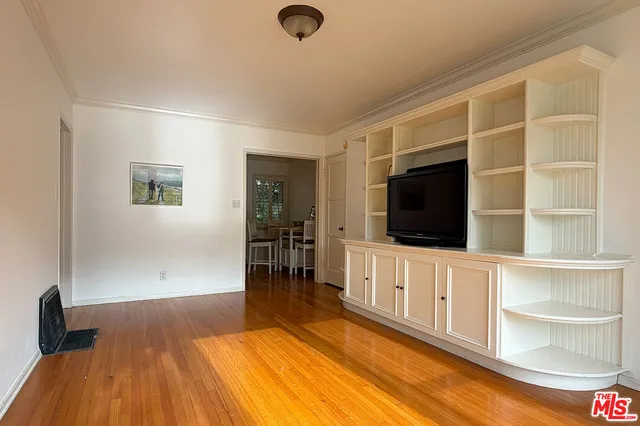 a living room with a flat screen tv and a wooden floor