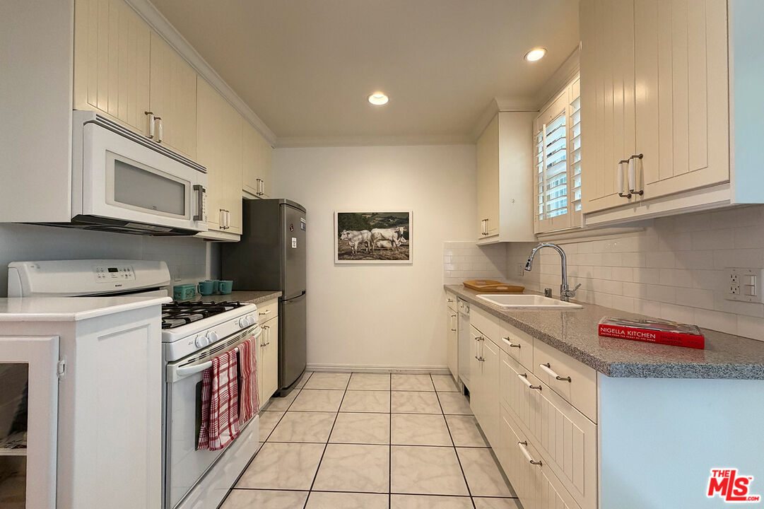 1701 Washington Avenue Santa Monica, CA 90403 - Photo 6 of 15 a kitchen with stainless steel appliances granite countertop a stove sink and cabinets
