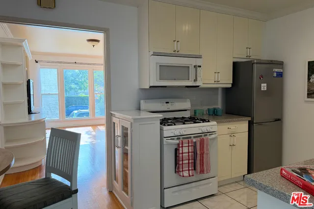 a kitchen with stainless steel appliances granite countertop a stove a refrigerator and a cabinets