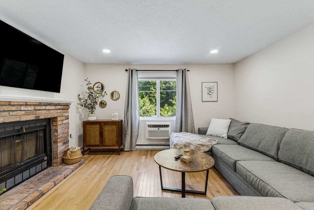 10 Erick Road, Unit 42 Mansfield, MA 02048 - Photo 5 of 33 a living room with furniture a flat screen tv and a fireplace