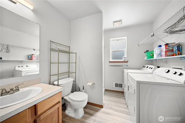 a bathroom with a sink toilet vanity and window