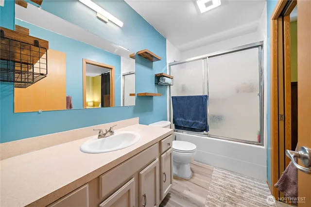 a bathroom with a sink a toilet and shower