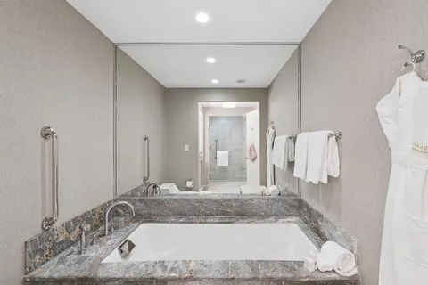 a bathroom with a granite countertop sink and a mirror