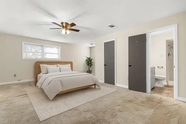 a bedroom with a large bed and a chandelier