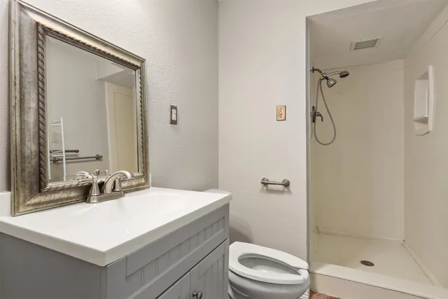 a bathroom with a sink a toilet and shower